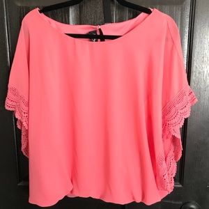 Coral colored top with lace detail along sleeves